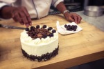 Chef is placing the cherries on top of each rosette.