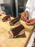 Chef is placing the raspberry on one side of each rosette.